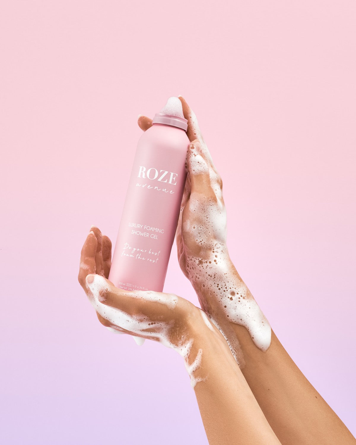 Żel pod prysznic Roze Avenue trzymany w rękach kobiety. Ręce kobiety są pokryte pianą Żelu Roze Avenue