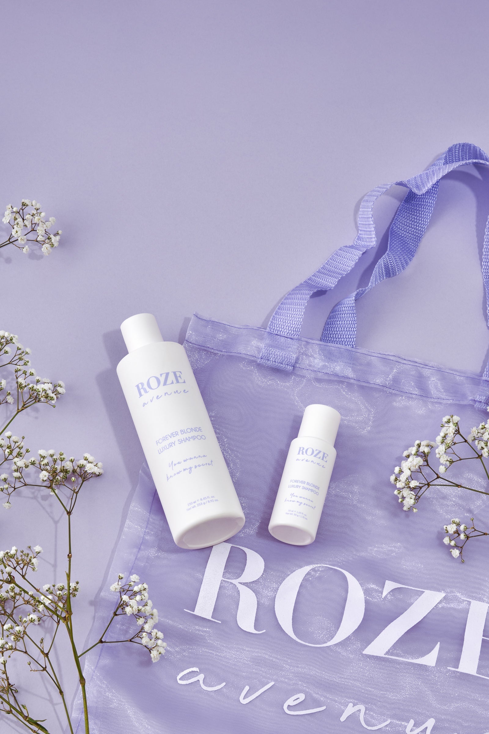 dwa fioletowe szampony roze avenue - mały i duży na torbie roze