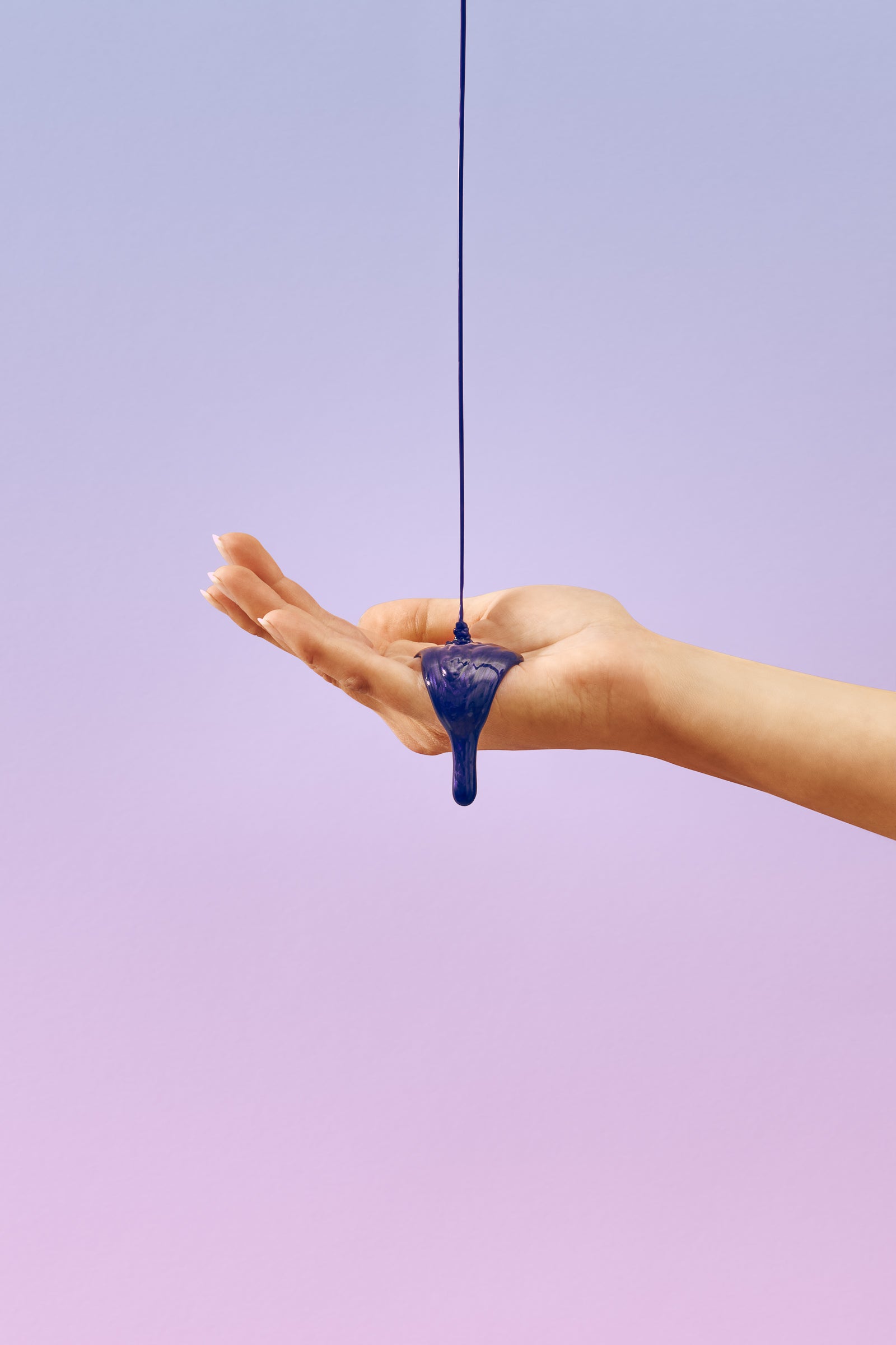 fioletowy szampon wylany na dłoń kobiety