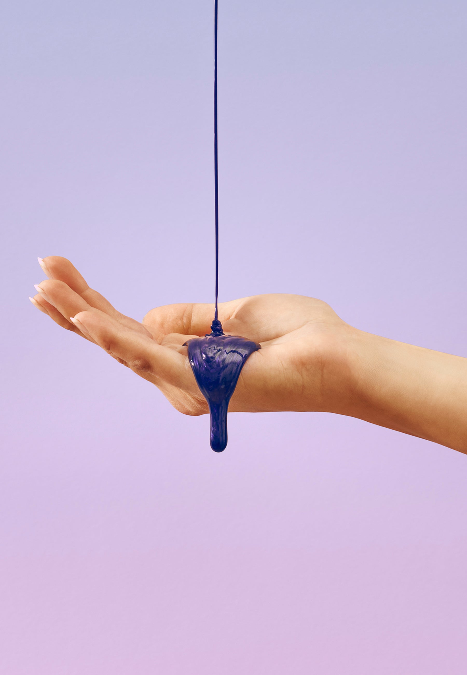 fioletowy szampon wylany na dłoń kobiety